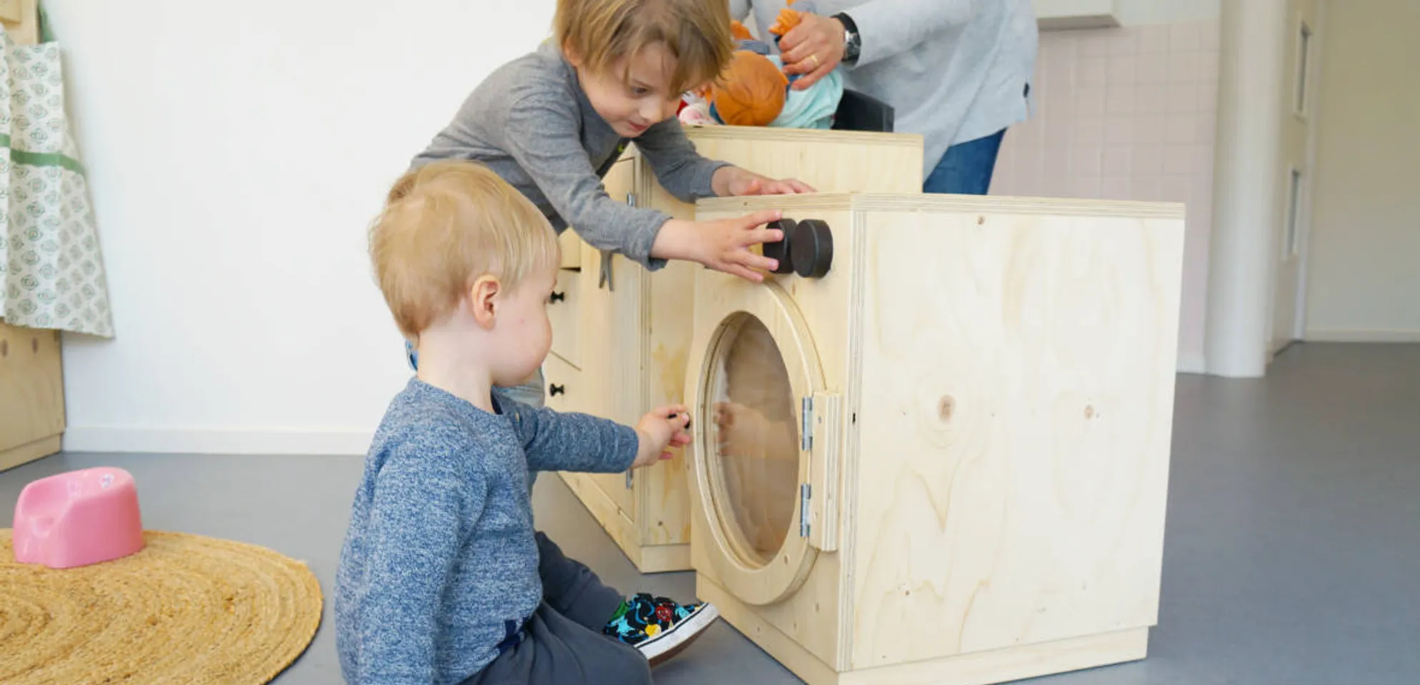 Kinderen spelen met een speelgoedwasmachine bij Kinderdagverblijf Abcoude Droomboom van kinderopvang Kind&co ludens