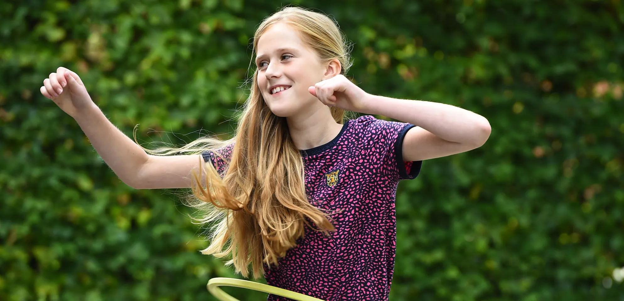Kind van de BSO hoepelt buiten bij kinderopvang Kind&co ludens