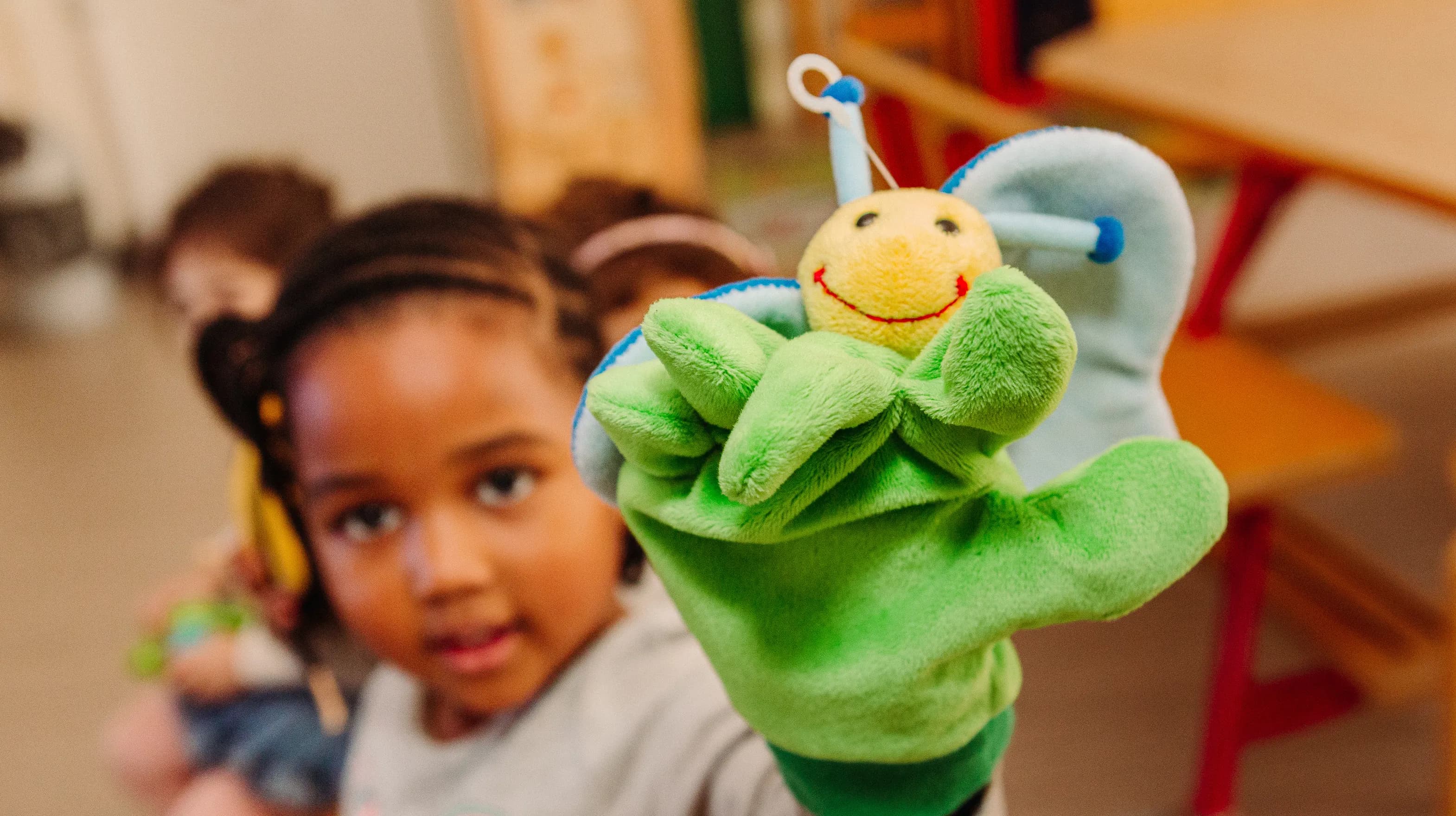 Kind van de peutergroep speelt met handpop bij kinderopvang Kind&co ludens