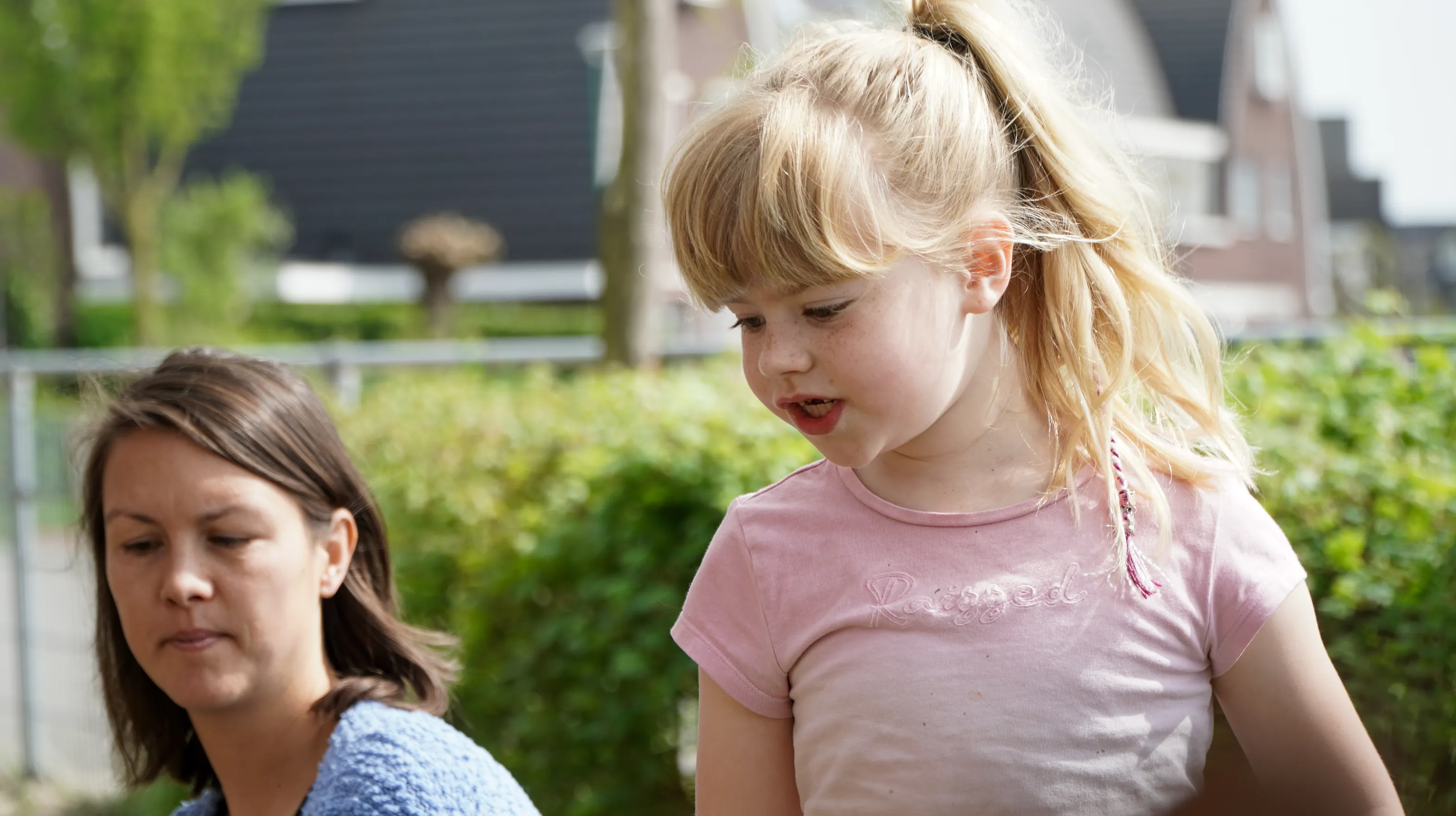 Kind voor de heg met gastouder van kinderopvang Kind&co ludens