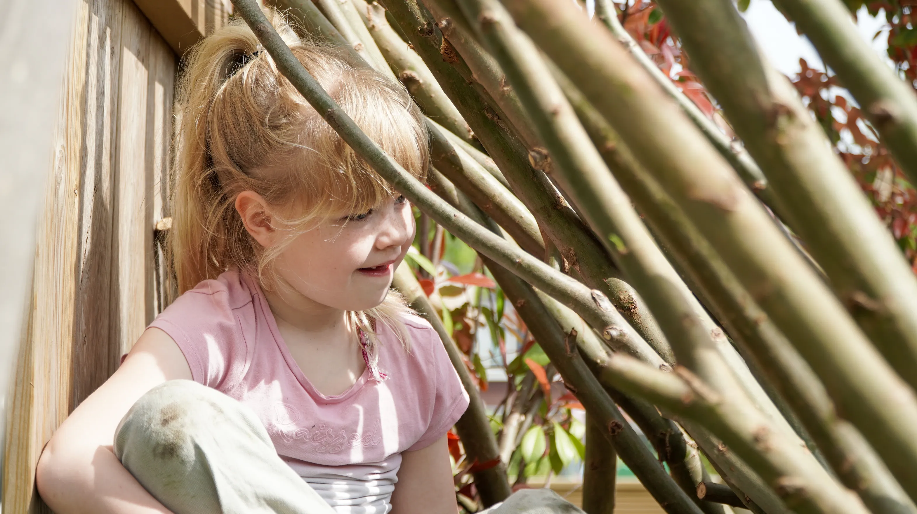 Kind speelt buiten in Wilgentakken huisje bij gastouder van kinderopvang Kind&co ludens