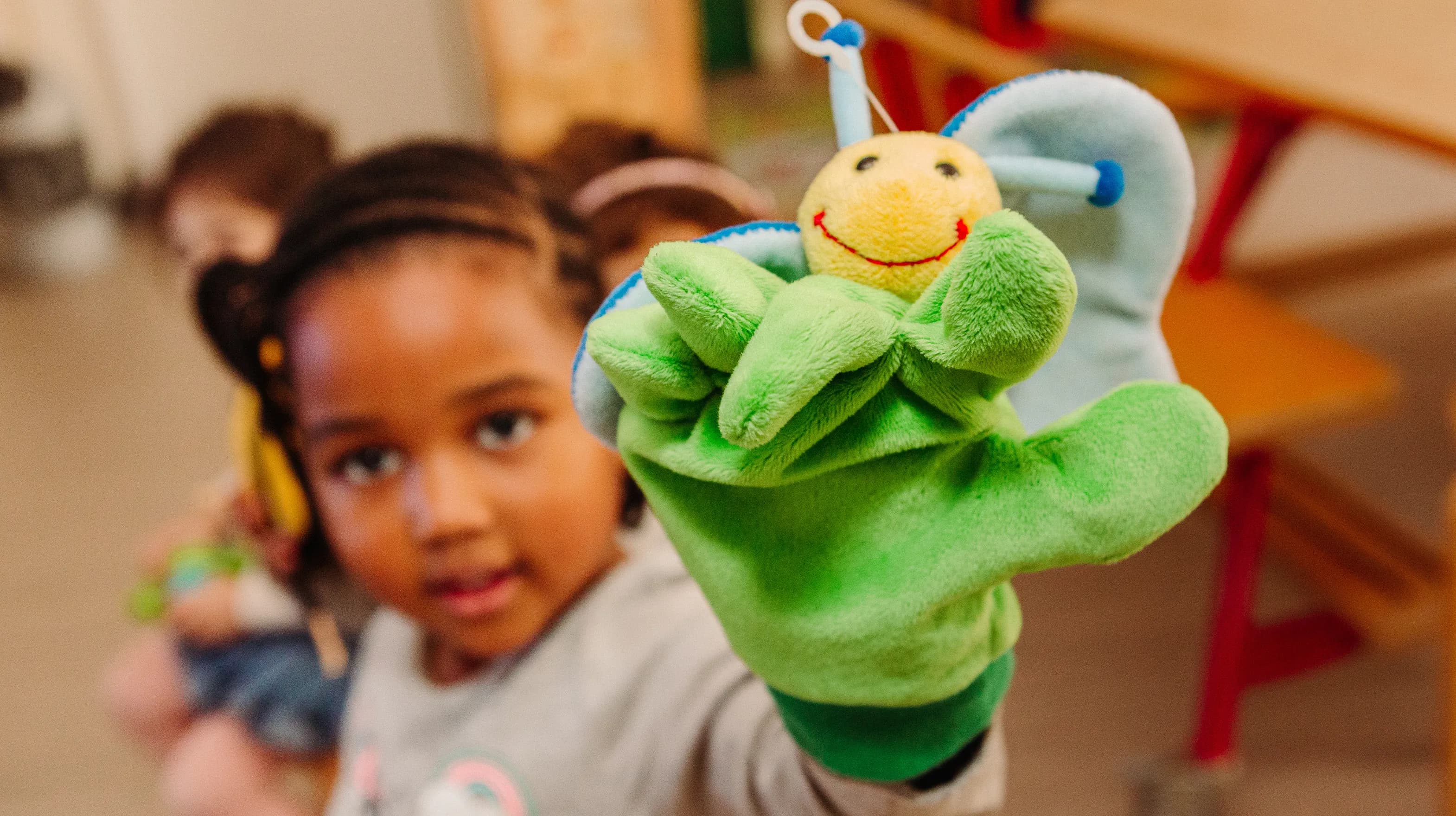 Kind van de peutergroep speelt met handpop bij kinderopvang Kind&co ludens
