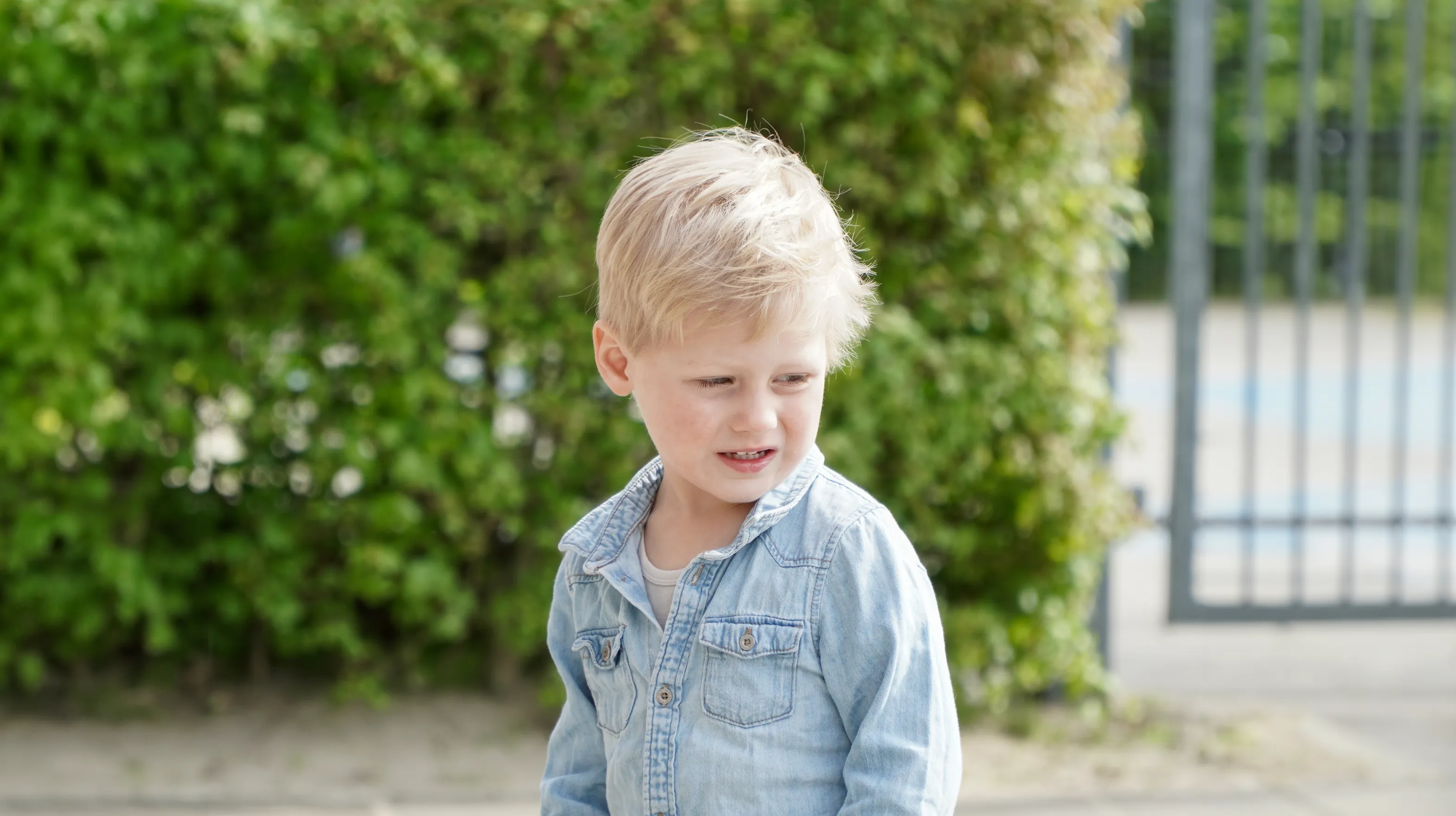 Kind staat buiten bij de heg bij gastouder van kinderopvang Kind&co ludens
