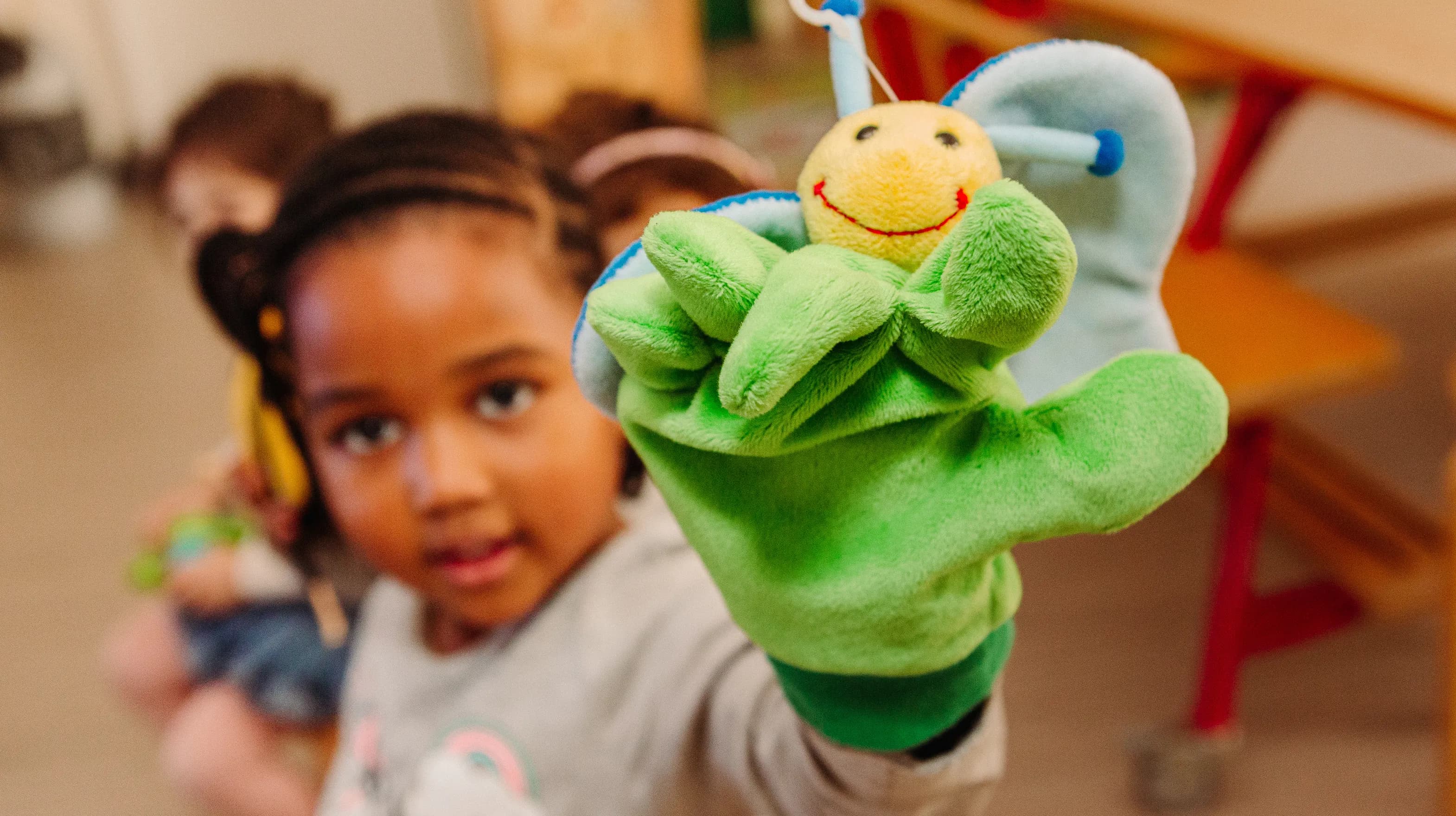 Kind van de peutergroep speelt met handpop bij kinderopvang Kind&co ludens