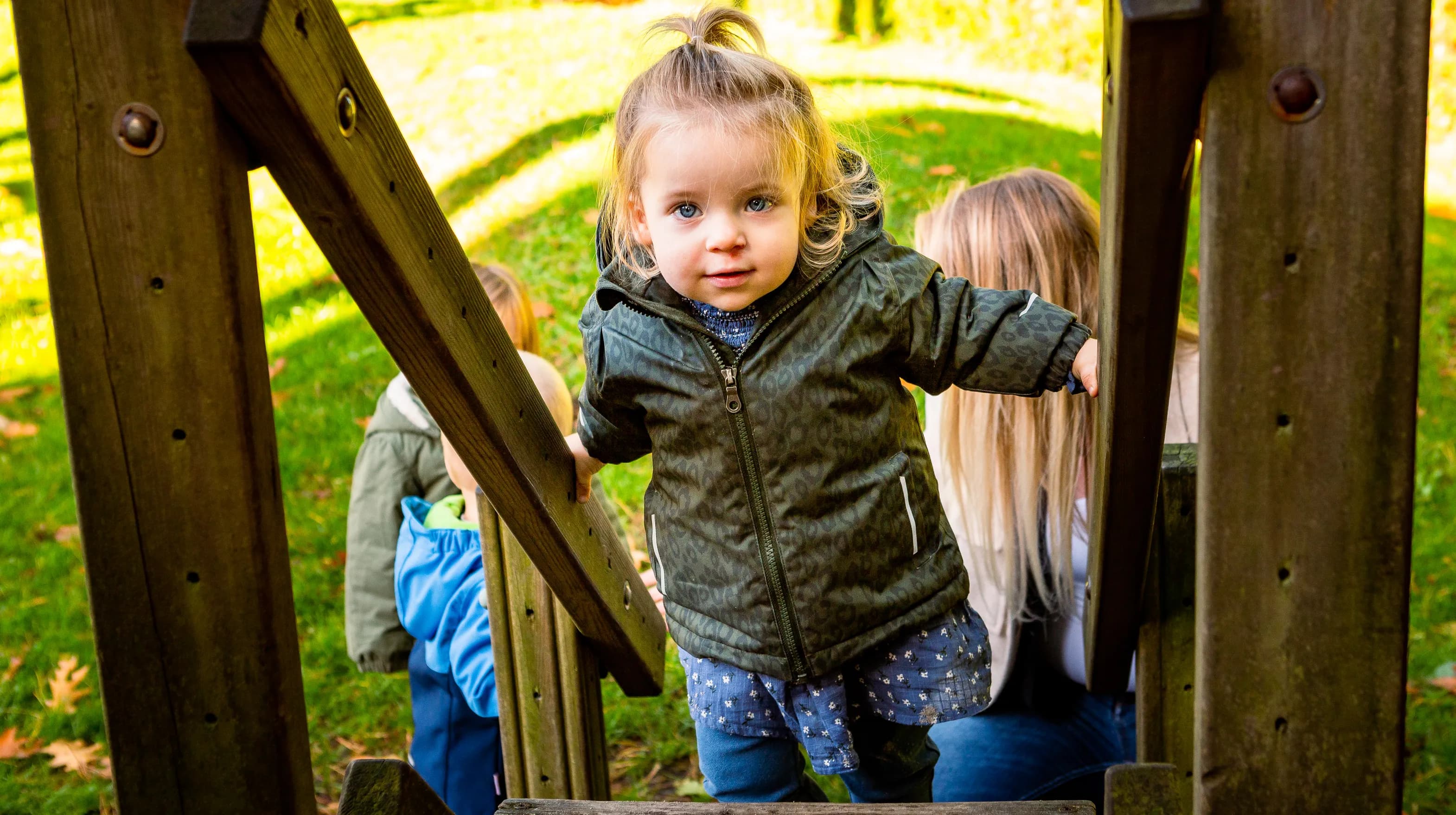 Kind speelt buiten op een speeltoestel bij kinderopvang Kind&co ludens