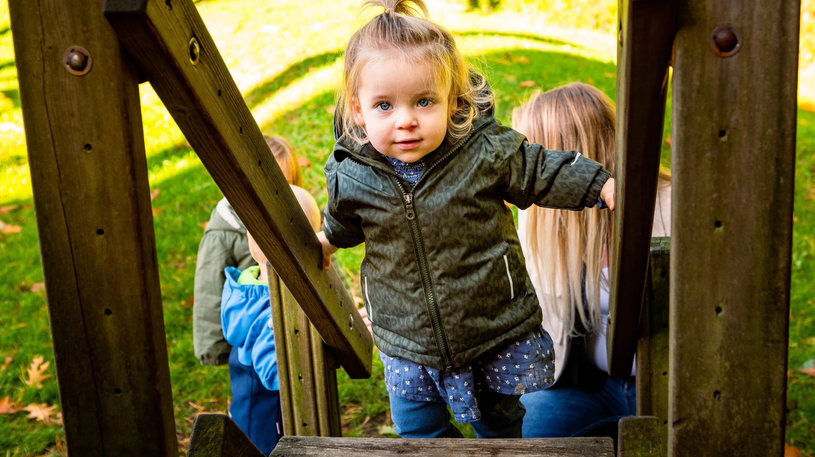 Kind speelt buiten op een speeltoestel bij kinderopvang Kind&co ludens