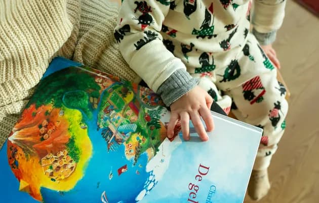 Kind leest boek bij kinderdagverblijf avontuur van kinderopvang Kind&co Ludens