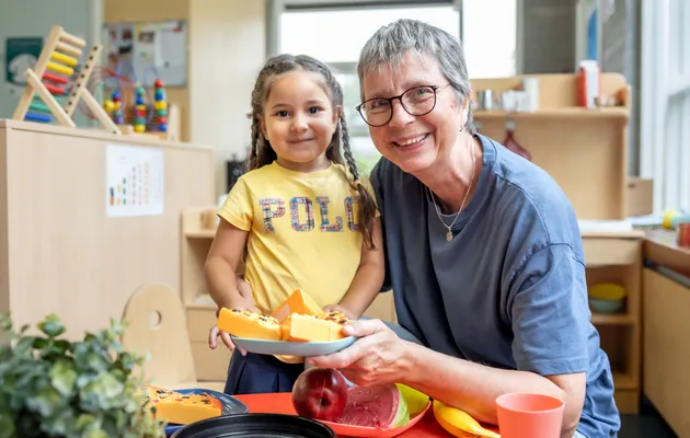 Kind speelt met pedagogisch medewerker in kinderkeuken bij kinderopvang Kind&co ludens