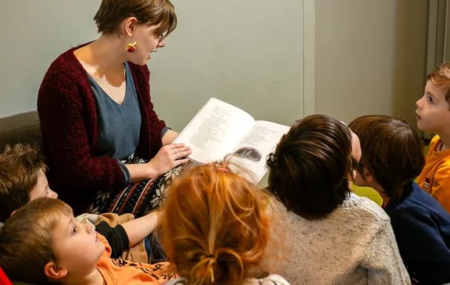 Pedagogisch medewerker leest kinderen voor bij buitenschoolse opvang Odin, Kind&co Ludens