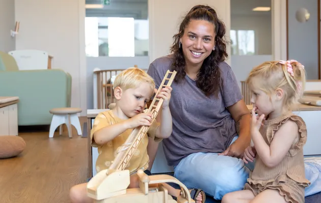 Kinderen spelen samen met pedagogisch medewerker bij kinderopvang Kind&co ludens