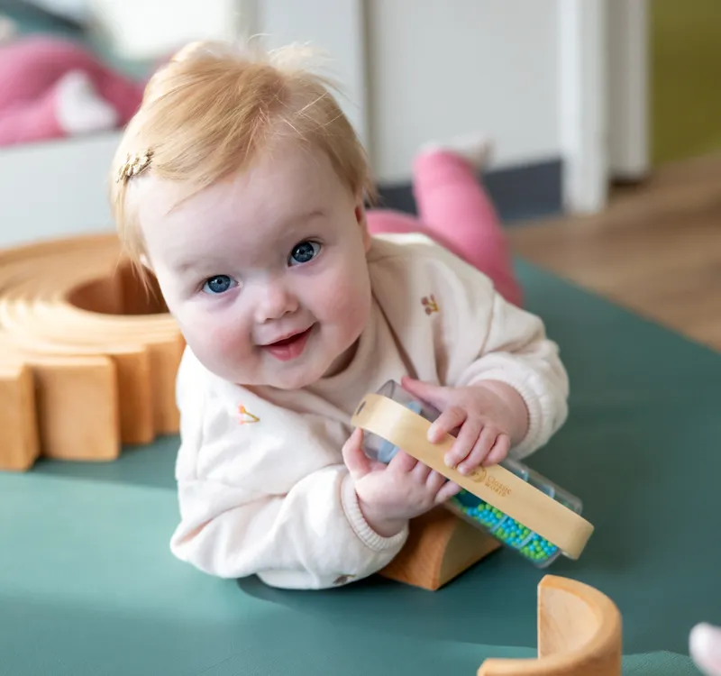 Baby speelt op een mat bij kinderopvang Kind&co ludens