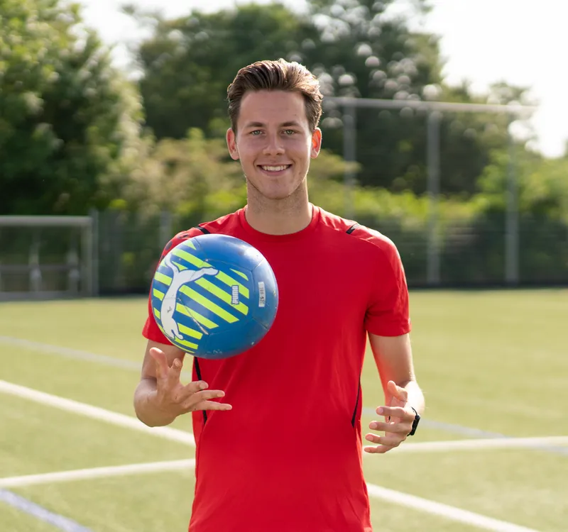 Collega met bal in zijn hand op een sportveld op de BSO