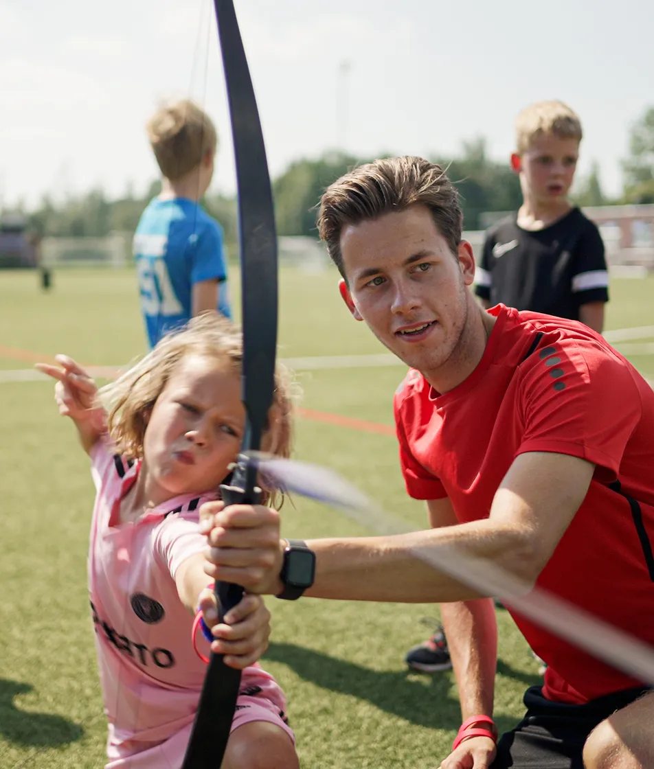 Collega leert kind boogschieten op de BSO