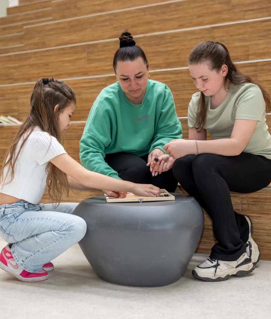 Kinderen spelen een spel met pedagogisch medewerkers bij kinderopvang Kind&co ludens