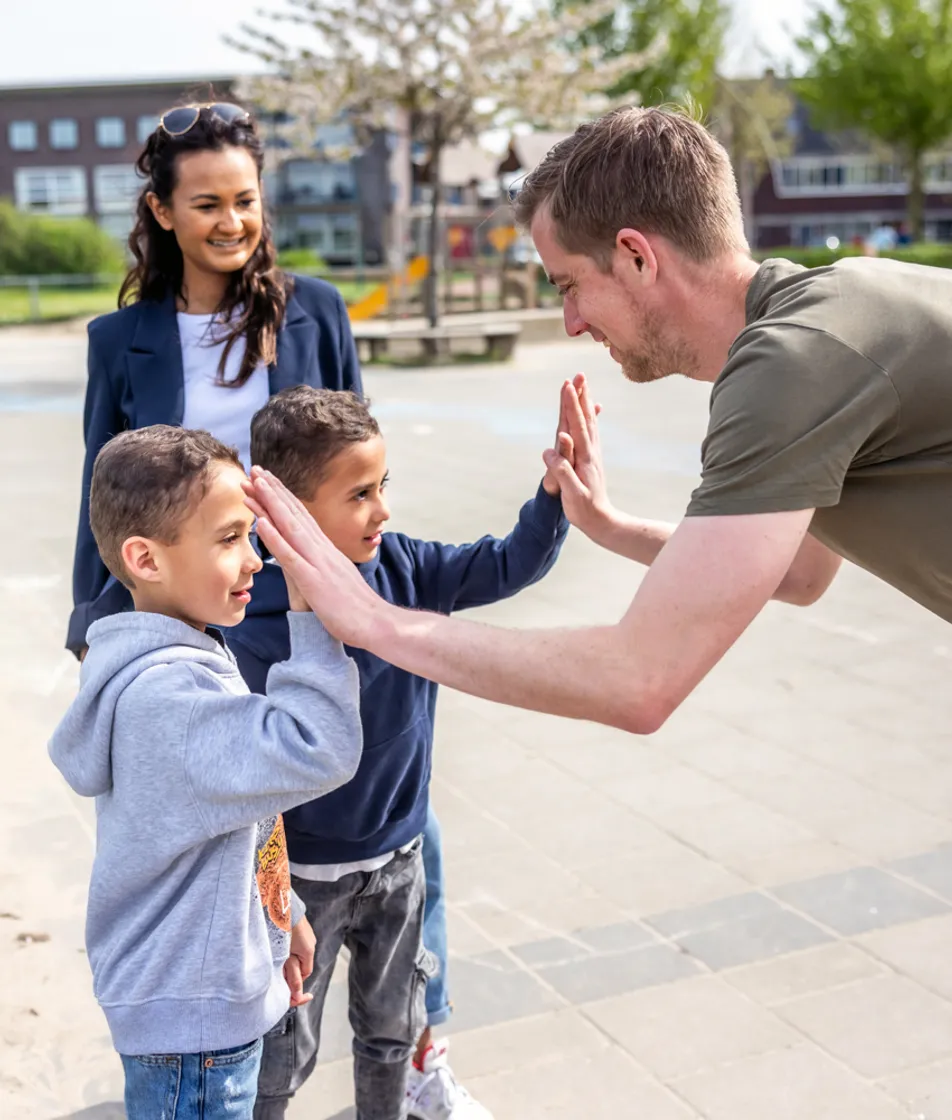 Pedagogisch medewerker geeft een high five bij kinderopvang Kind&co ludens