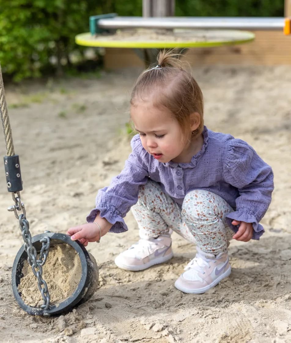 Kind speelt buiten bij kinderopvang Kind&co ludens