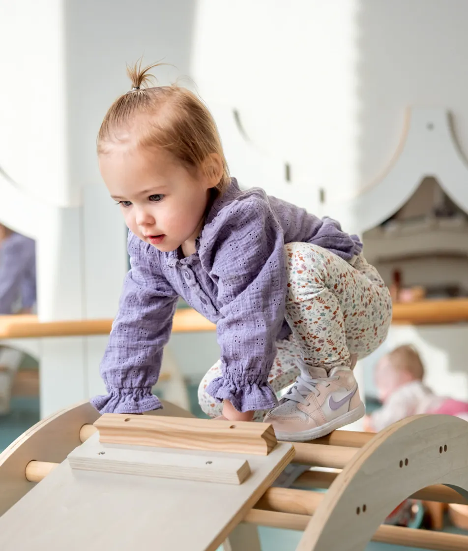 Kind klimt op klimrekje bij kinderopvang Kind&co ludens