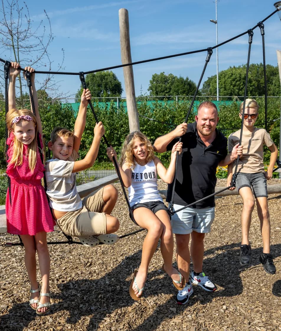 Kinderen spelen buiten met pedagogisch medewerker bij kinderopvang Kind&co ludens