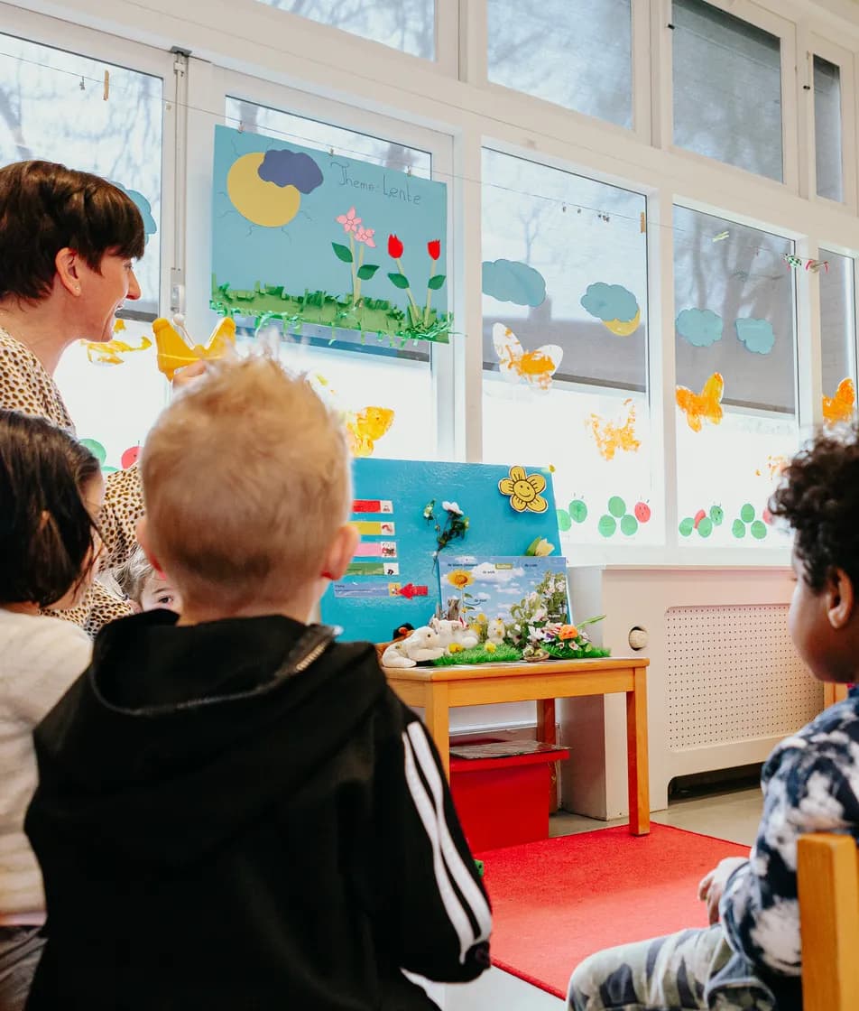 Kinderen zitten in kring bij Kind&co ludens