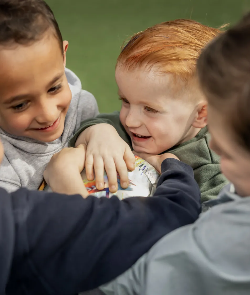 Kinderen spelen een bal en lachen met elkaar bij kinderopvang Kind&co ludens