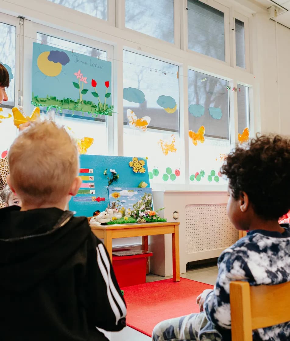 Kinderen zitten in kring bij Kind&co ludens