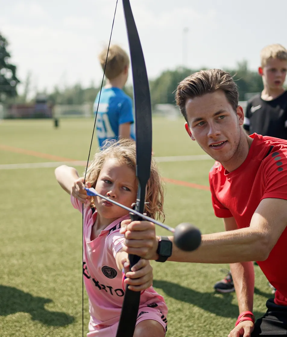 Collega leert kind boogschieten op de BSO