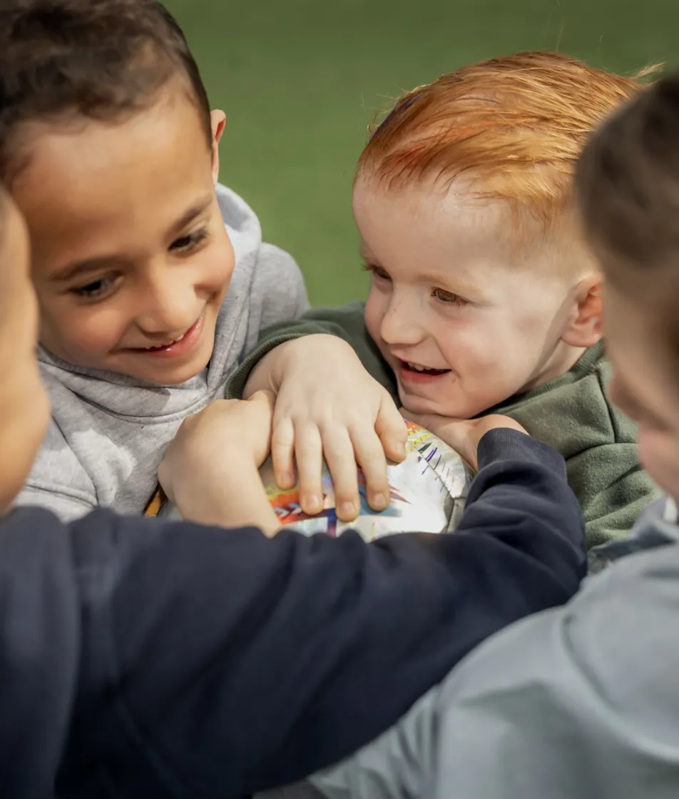 Kinderen spelen een bal en lachen met elkaar bij kinderopvang Kind&co ludens