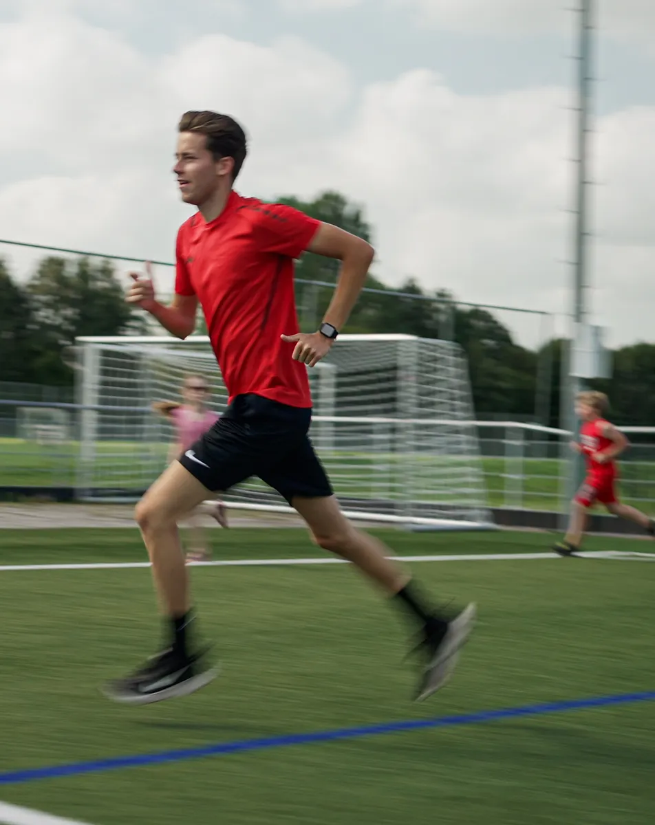 Een collega rent met kinderen op de BSO