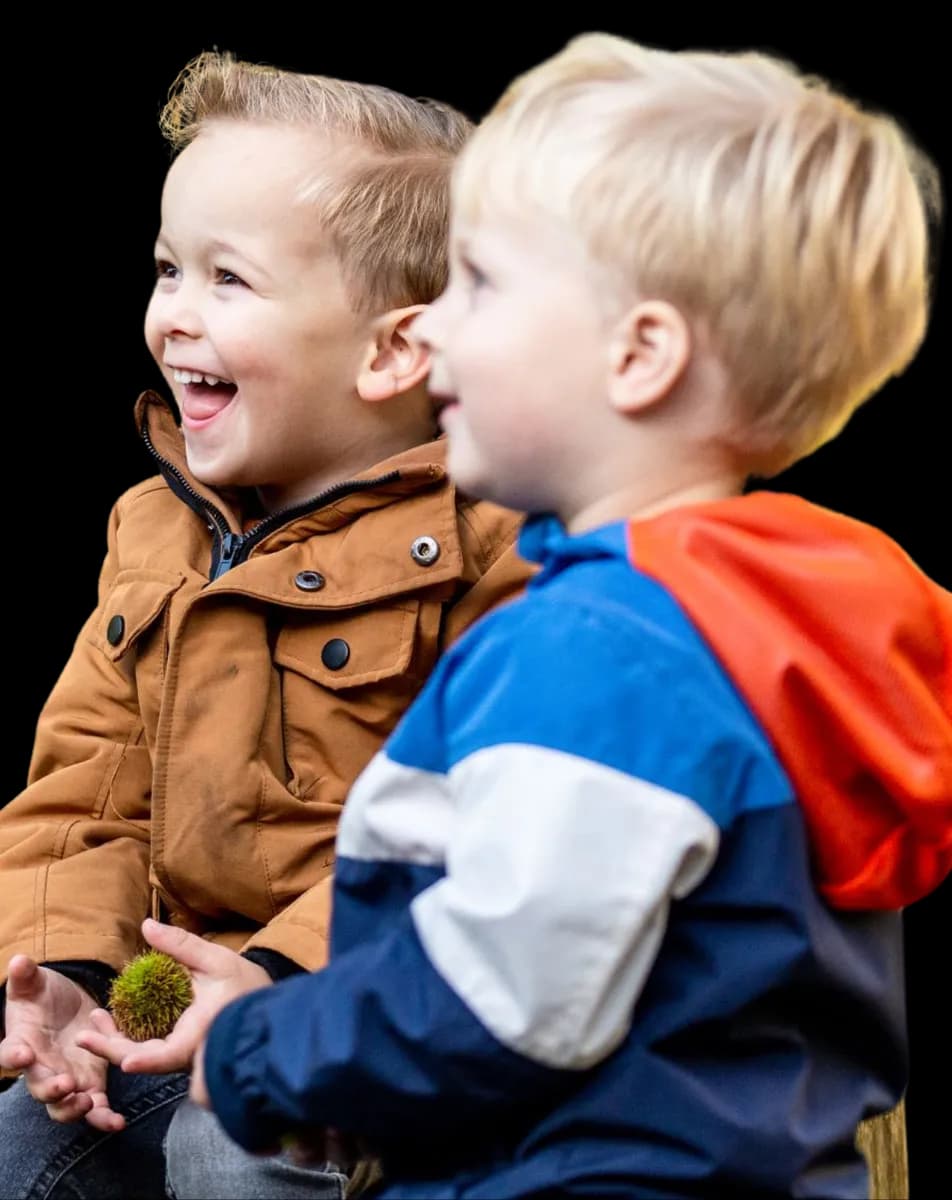 Kinderen zitten bij elkaar en lachen bij kinderopvang Kind&co ludens